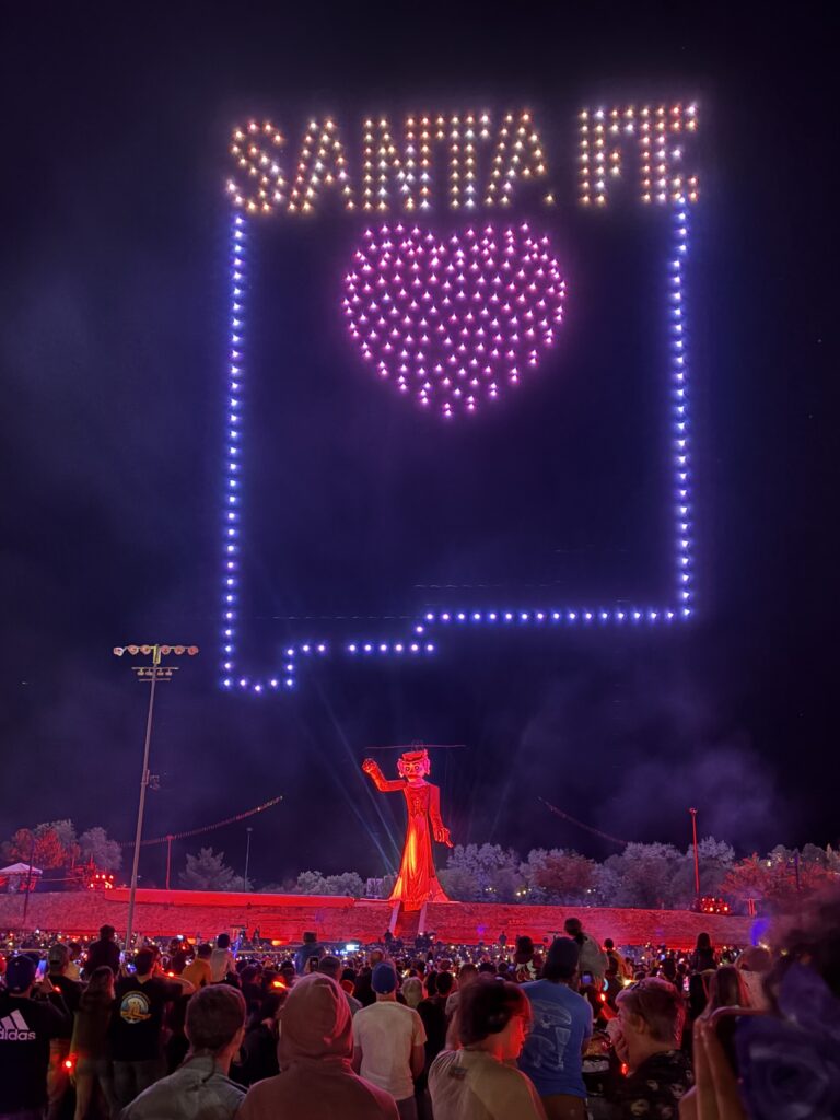 Zozobra illuminated in purple lights during the Burning of Zozobra in Santa Fe.